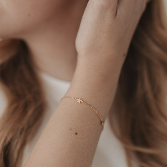Detailaufnahme vom Armband Jackie Gold mit Sternanhänger am Handgelenk, zart und elegant getragen.