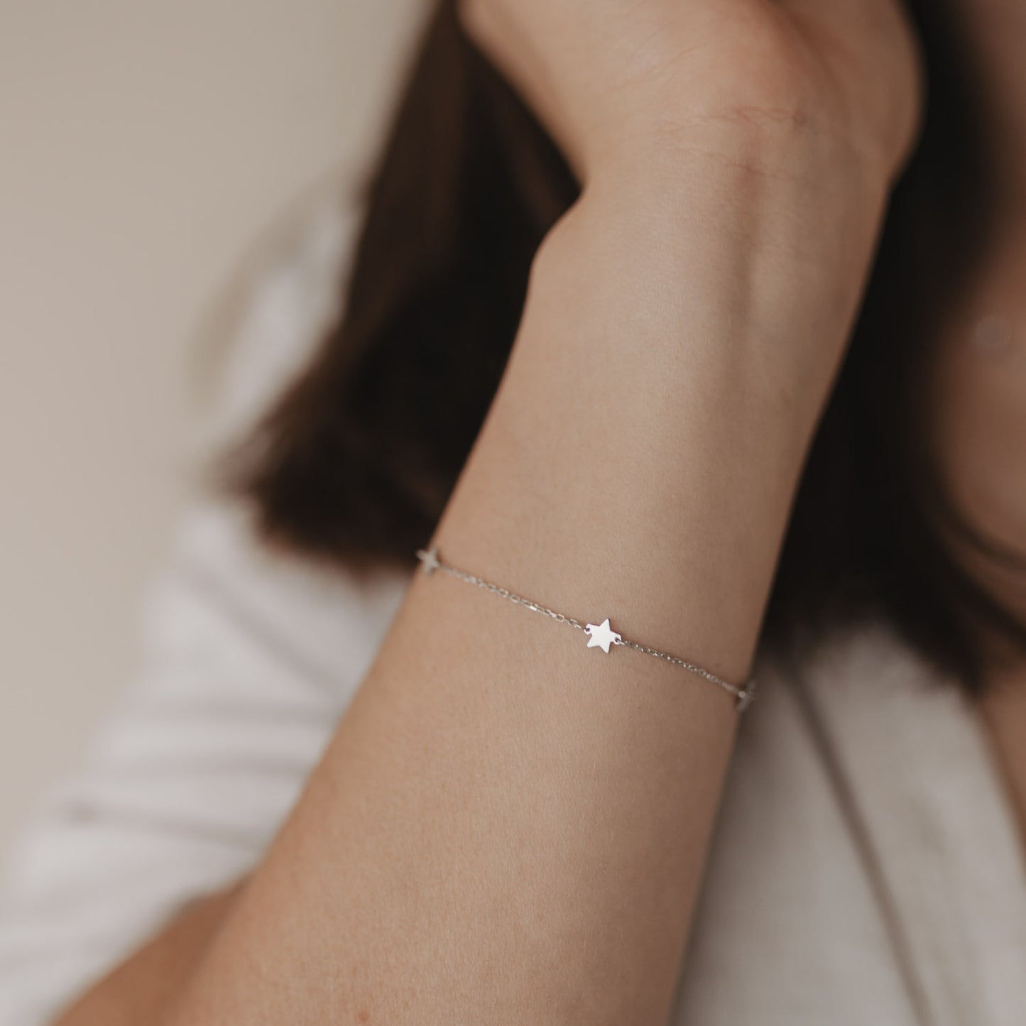 Nahaufnahme des Armbands Jackie Silber mit Sternen am Handgelenk einer Frau.
