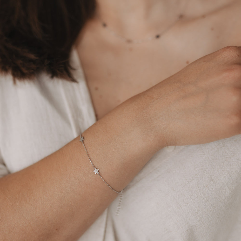 Tragebild des Armbands Jackie Silber mit drei kleinen Sternen an zartem Handgelenk.