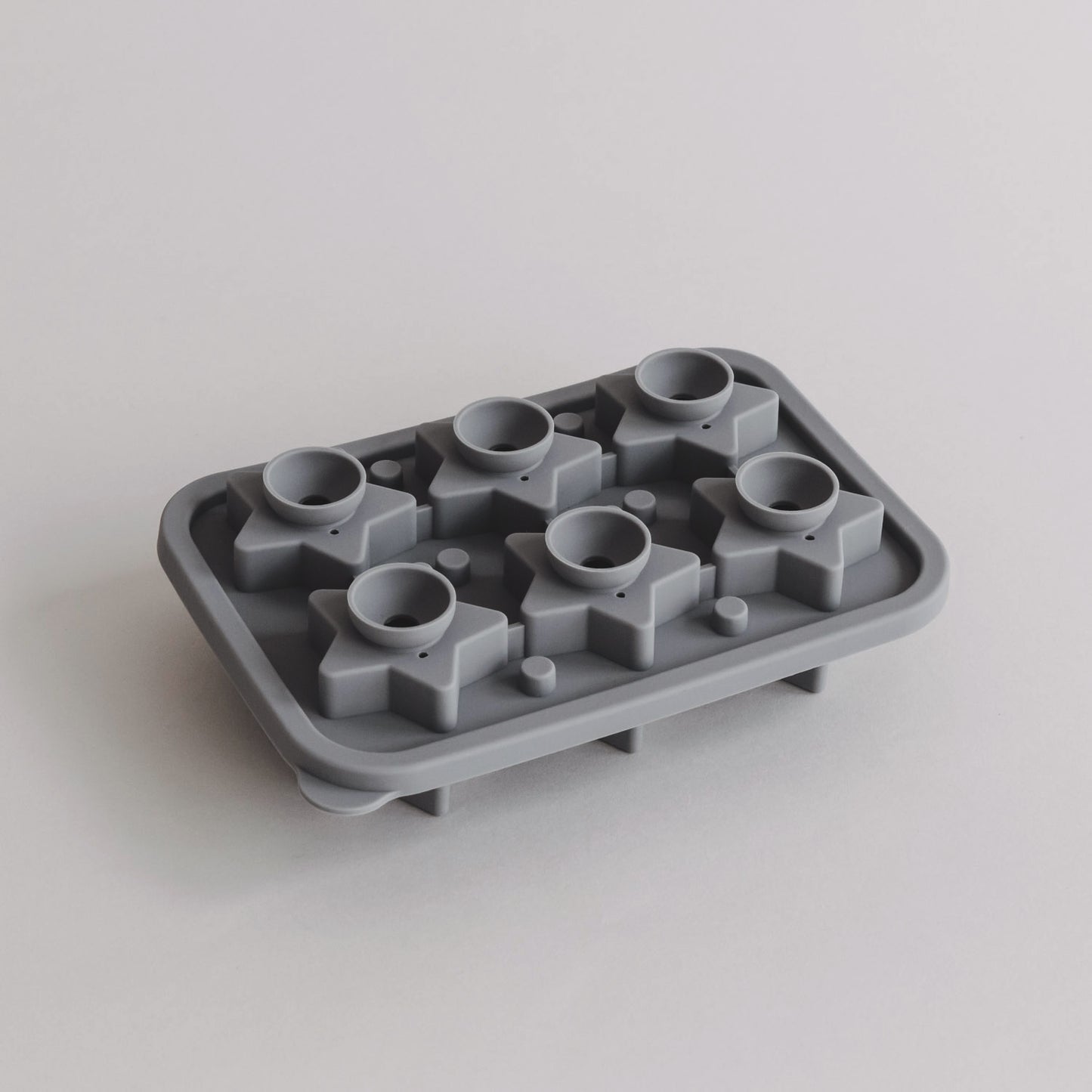 Geöffnete Eiswürfelform mit sternförmigen Kammern und runden Einfüllöffnungen in Draufsicht.