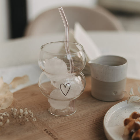 Transparentes Glas mit Herz und mehreren Eis-Kugeln, ideal für kühle Sommergetränke.