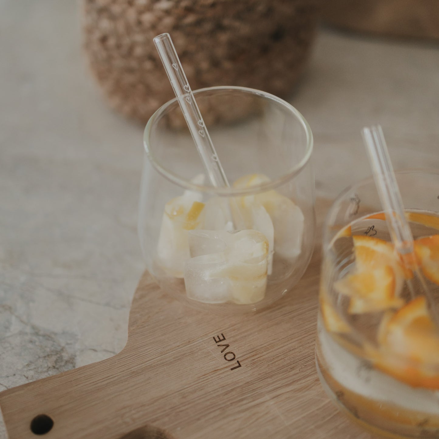 2 Gläser gefüllt mit Hasen-Eiswürfeln und Orangen- und Zitronenscheiben. Seitliche Ansicht.