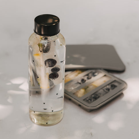 Trinkflasche mit Eiswürfel Stick aus Früchten, daneben Eiswürfelform für längliche Ice Sticks