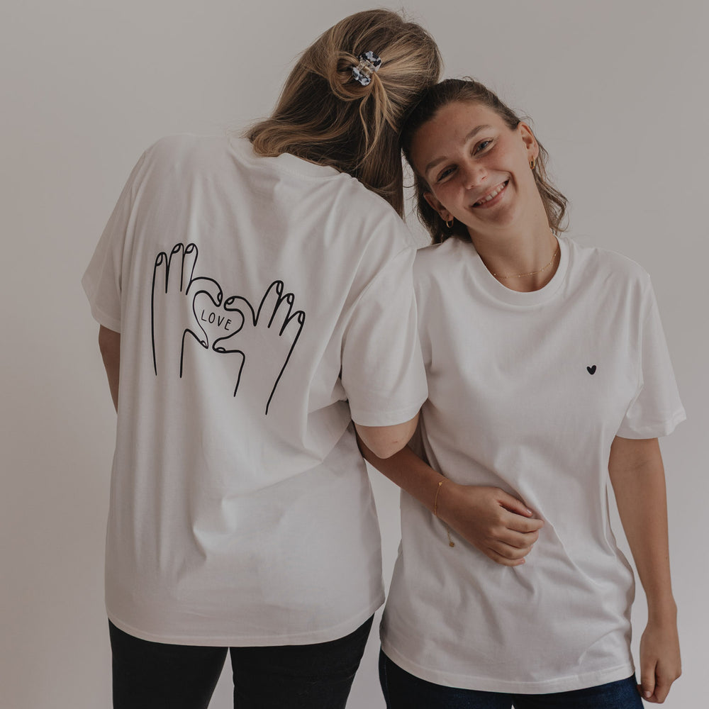 Zwei Frauen im Partnerlook mit LOVE-T-Shirts, eine lächelt zur Kamera
