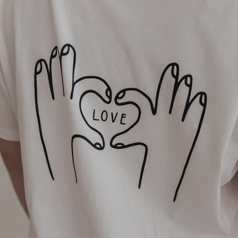 Close-up Rückenansicht LOVE Shirt mit schwarzem Herz-Hand-Motiv auf Weiß