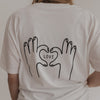 Rückenansicht: Hände formen ein Herz mit "LOVE"-Schriftzug auf T-Shirt
