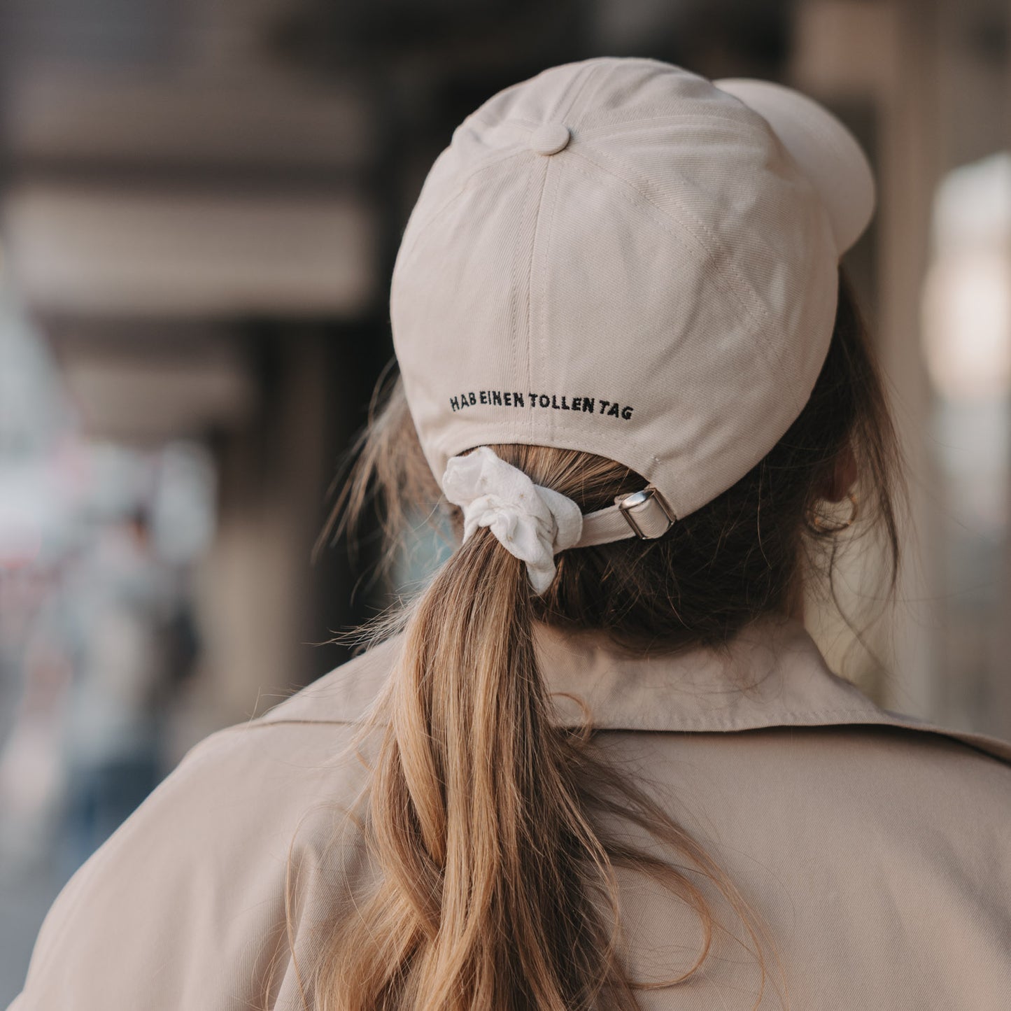 Rückseite beige Cap mit Schriftzug „Hab einen tollen Tag“ und verstellbarem Verschluss