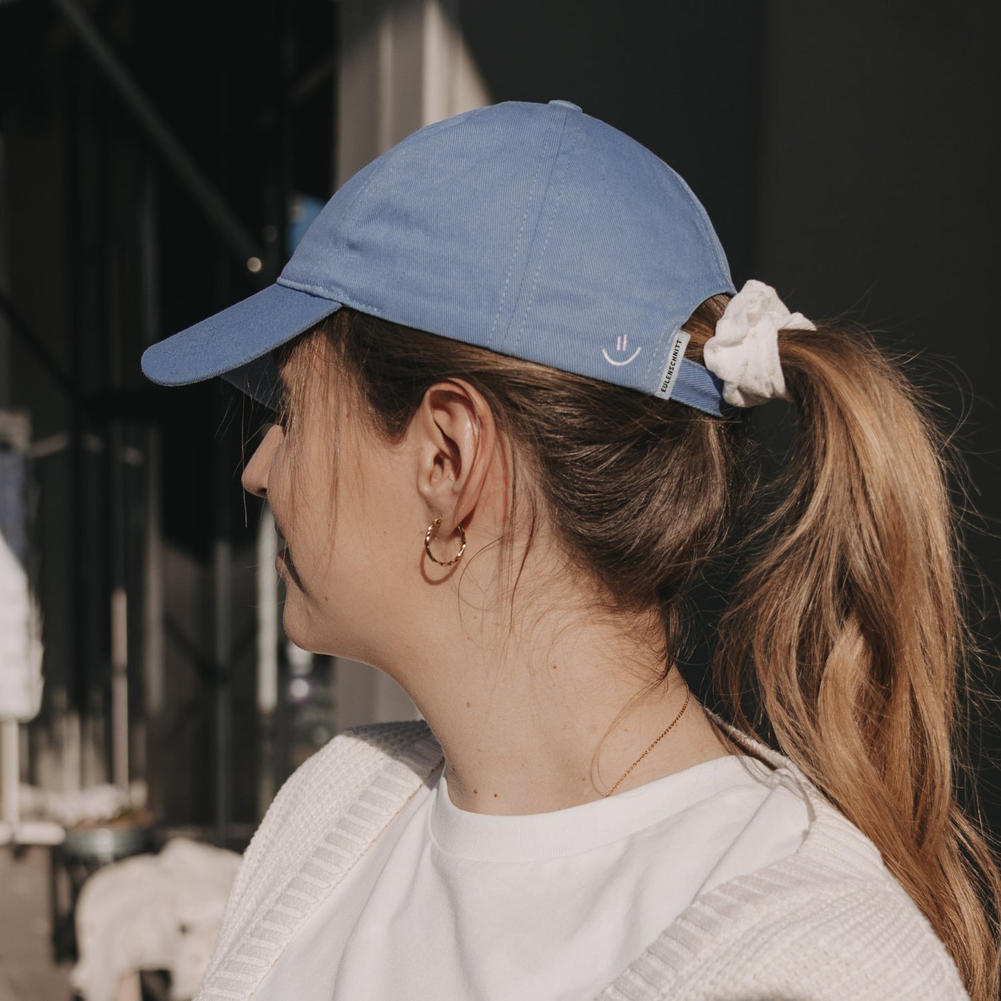 Seitenansicht hellblaue Cap mit Smiley-Stickerei und Pferdeschwanz