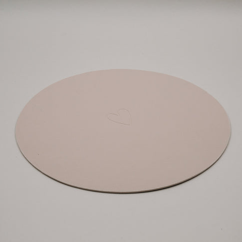 Rundes cremefarbenes Platzset von Eulenschnitt mit zart eingeprägtem Herzmotiv auf hellem Hintergrund.