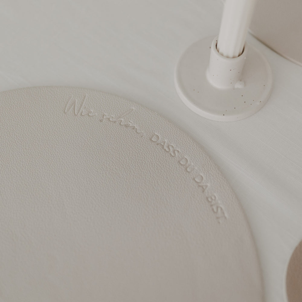 Detailaufnahme des Platzsets in Creme mit Schriftzug „Wie schön, dass du da bist“.