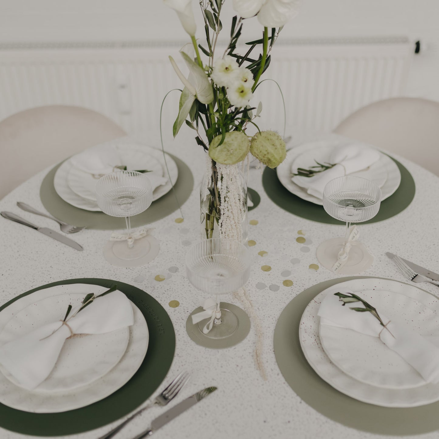 Festlich gedeckter Tisch mit grünen Platzsets und stilvoller Tischdekoration.