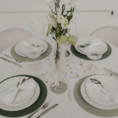 Festlich gedeckter Tisch mit grünen Platzsets und stilvoller Tischdekoration.