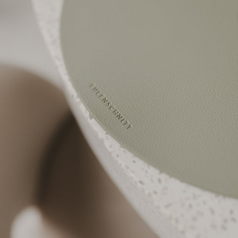 Detailaufnahme des Eulenschnitt-Logos auf hellem grünen Platzset.