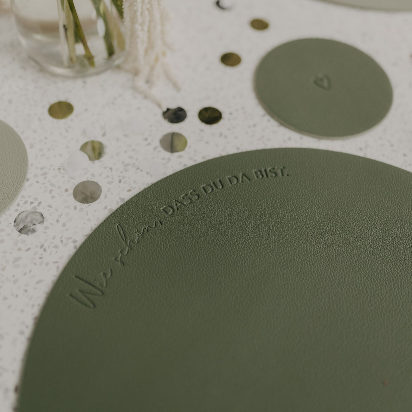 Grünes Platzset mit Prägung ‚Wie schön, dass du da bist‘ in Nahaufnahme.
