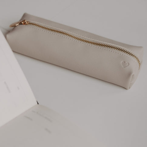 Minimalistische Federtasche taupe mit Herzprägung von Eulenschnitt neben Notizbuch