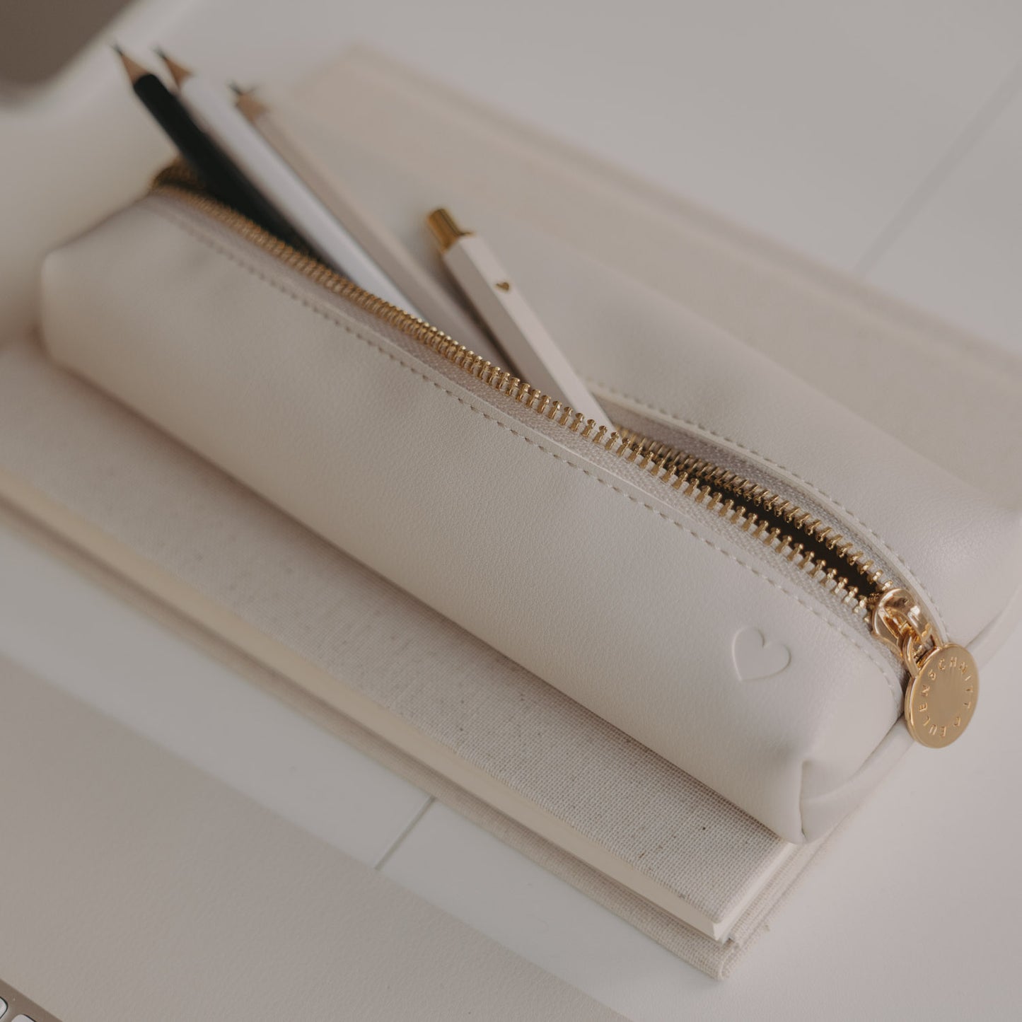 Federtasche creme von Eulenschnitt mit Herzprägung, geöffnet mit Bleistiften im Inneren