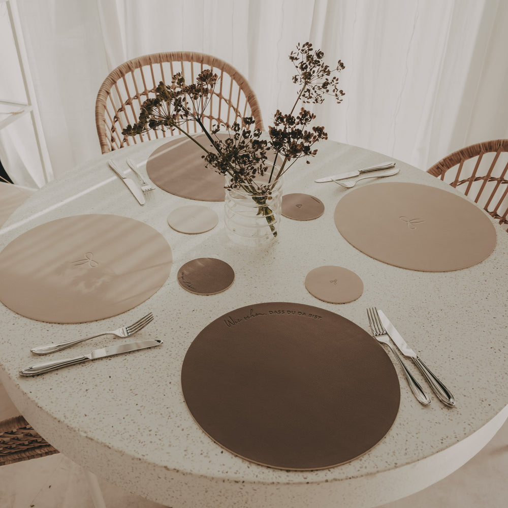 Wendbare Platzsets in Beige und Braun mit passenden Untersetzern auf gedecktem Esstisch