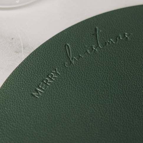 Detail des dunkelgrünen Platzsets mit geprägtem Merry-Christmas-Schriftzug