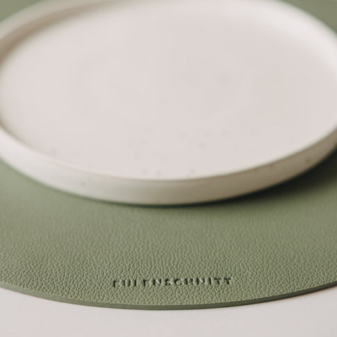 Detailaufnahme des salbeigrünen Platzsets in Lederoptik mit Eulenschnitt-Logo