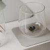 Hellgrauer eckiger Untersetzer mit Glas und schwarzem Herz als Detail