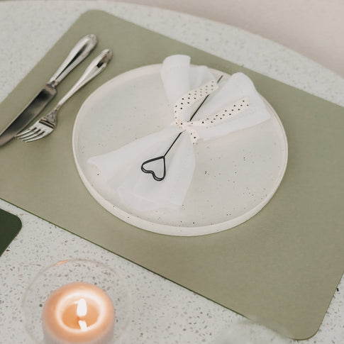 Hellgrünes Platzset mit Teller, Serviette und herzförmigem Serviettenhalter