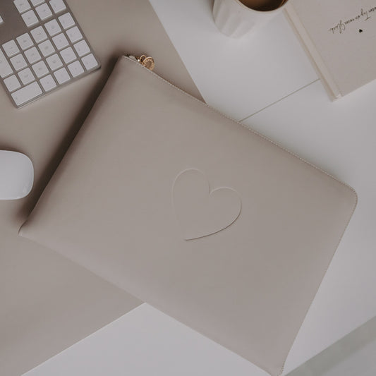 Laptophülle Taupe mit Herzprägung und Reißverschluss auf Schreibtisch neben Tastatur, Maus und Kaffee