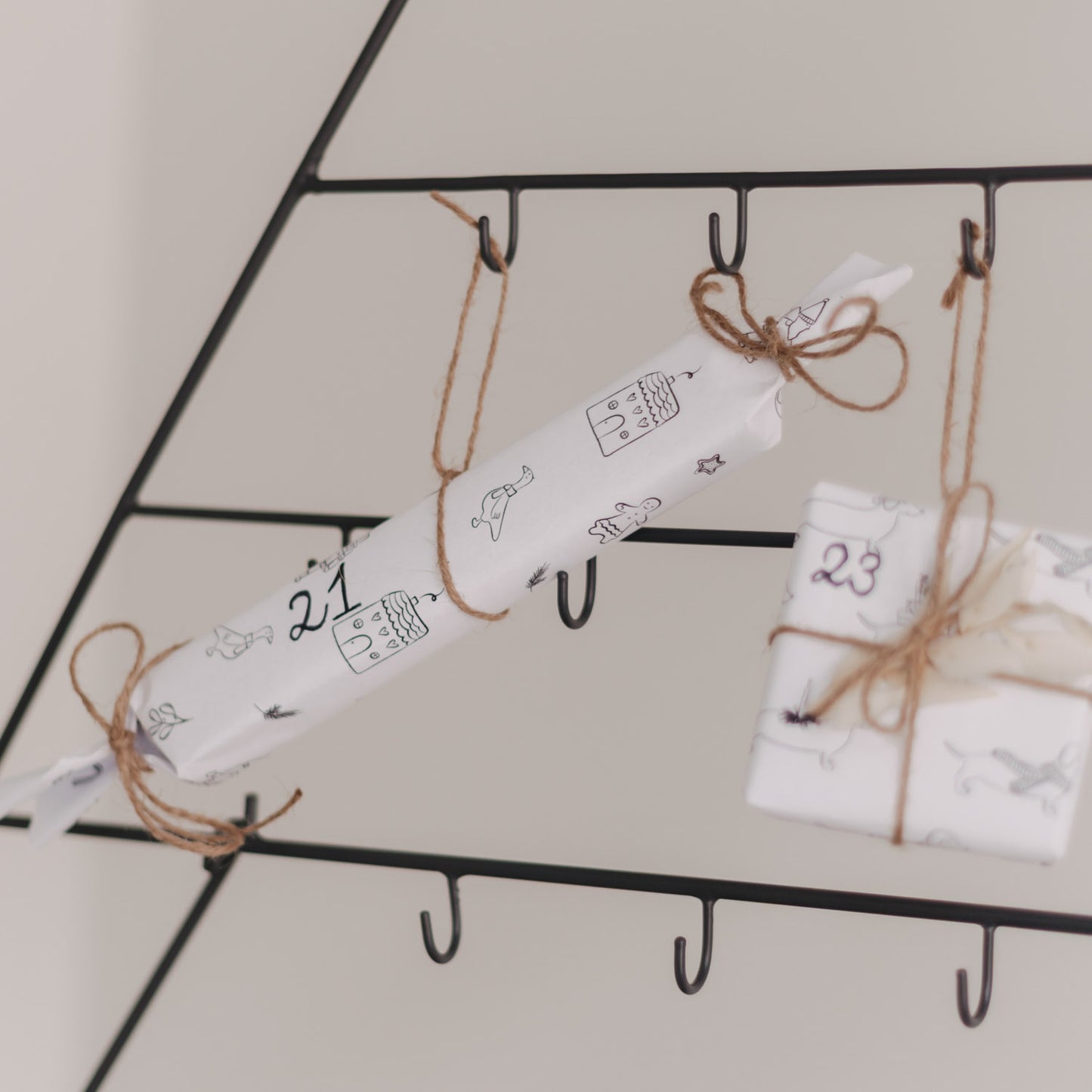 Verpacktes Geschenk mit Nummer 21 am Adventskalender Tanne befestigt.