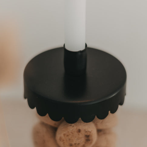 Detailansicht des schwarzen Kerzenhalters Welle mit eingesetzter Tannenbaumkerze auf einem Vorratsglas.