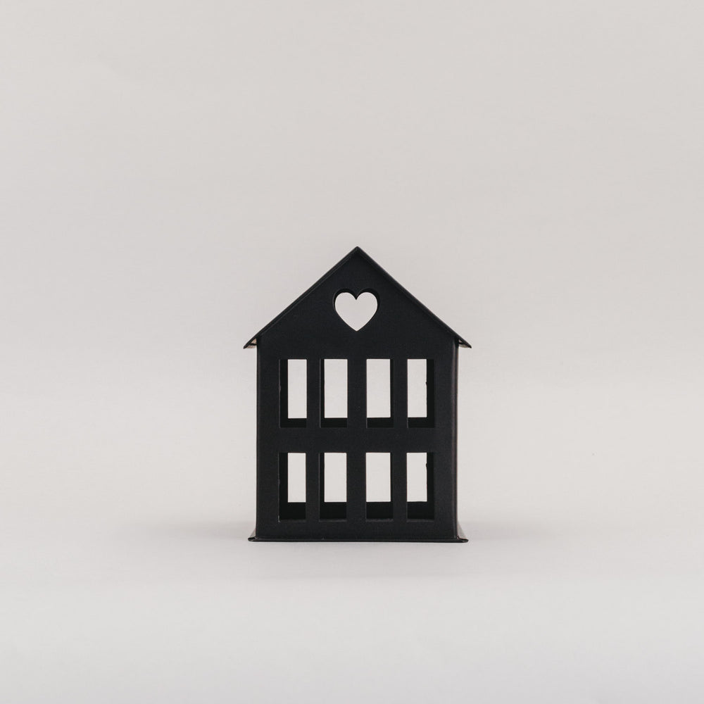 Schwarzes Metallhaus Mini mit Herz im Dach vor hellem Hintergrund – schlichtes Dekoelement aus Metall.