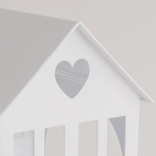 Detailaufnahme des weißen Metallhauses mit Herz-Ausschnitt im Dach, filigrane Verarbeitung.