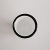 Emaille Tasse Herz von oben fotografiert – schlichtes Off-White Design mit schwarzem Rand.