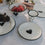 Weißer Emaille-Frühstücksteller mit schwarzem Herz im sommerlichen Picknick-Setting mit passendem Emaille-Geschirr.