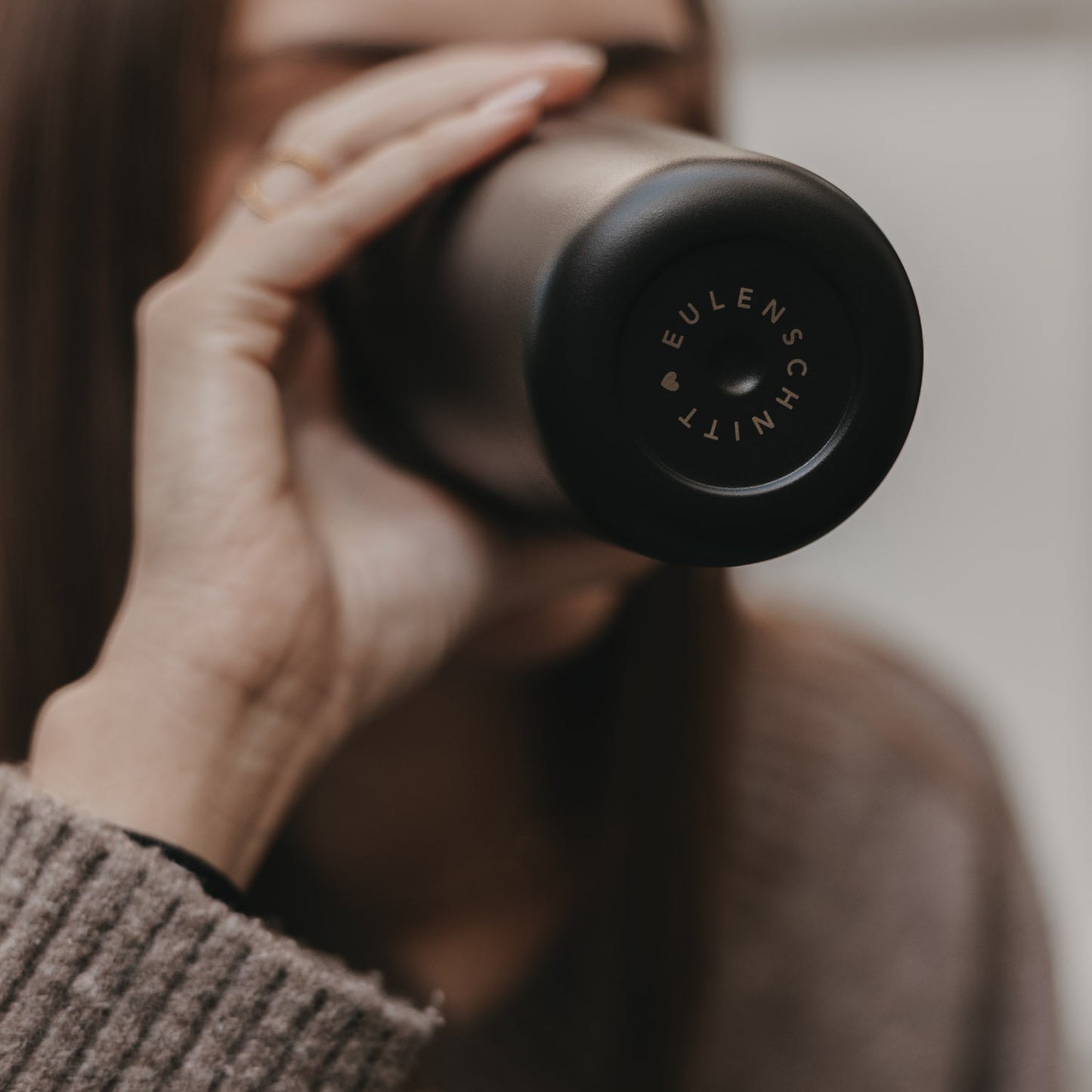 Detailaufnahme Becherboden mit Eulenschnitt Logo, hochwertiger To-go Becher Herz schwarz.
