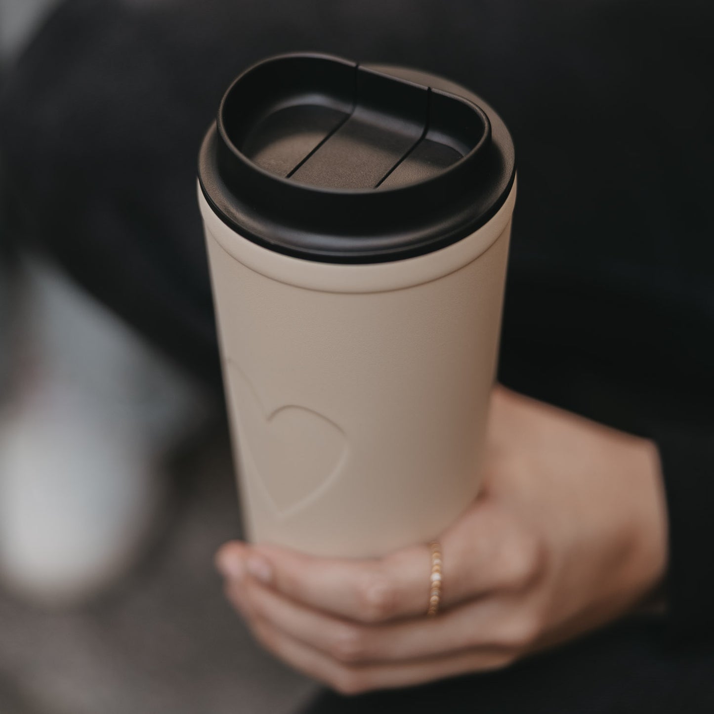 Nahaufnahme Becher Herz creme mit schwarzem Deckel, modernes Design und nachhaltiger Stil.