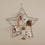 Adventskalender Stern groß aus Metall, dekoriert mit Geschenken, Karten und Anhängern an der Wand