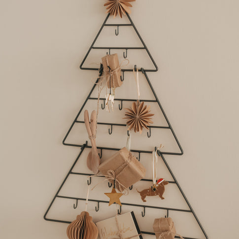 Adventskalender Tanne Metall dekoriert mit Geschenken, Holzlöffeln und weihnachtlichen Anhängern