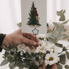 Anthrazitfarbener Stern Metallstecker als Kartenhalter in Blumenstrauß mit weihnachtlicher Grußkarte