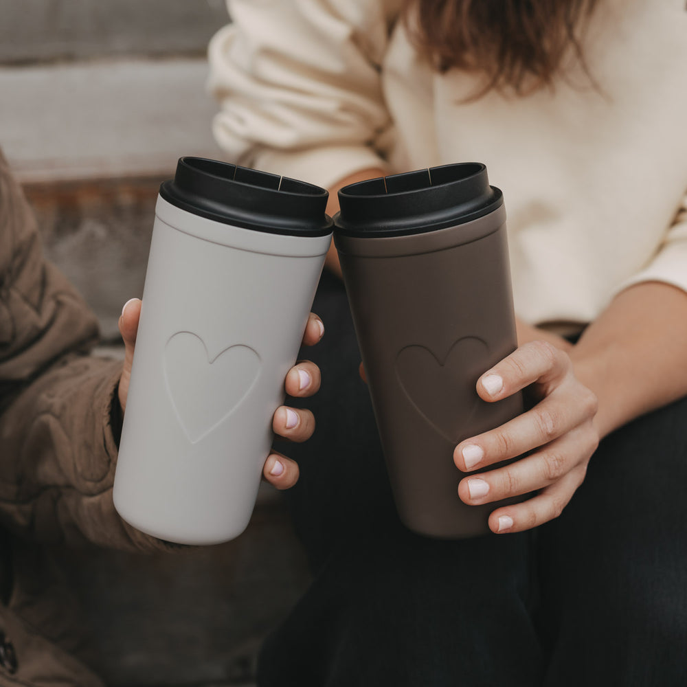 Zwei To-go-Thermobecher in Braun und Beige mit Herzmotiv und schwarzem Deckel