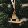 Rückseite goldener Schlitten Anhänger am Weihnachtsbaum, minimalistisches Design