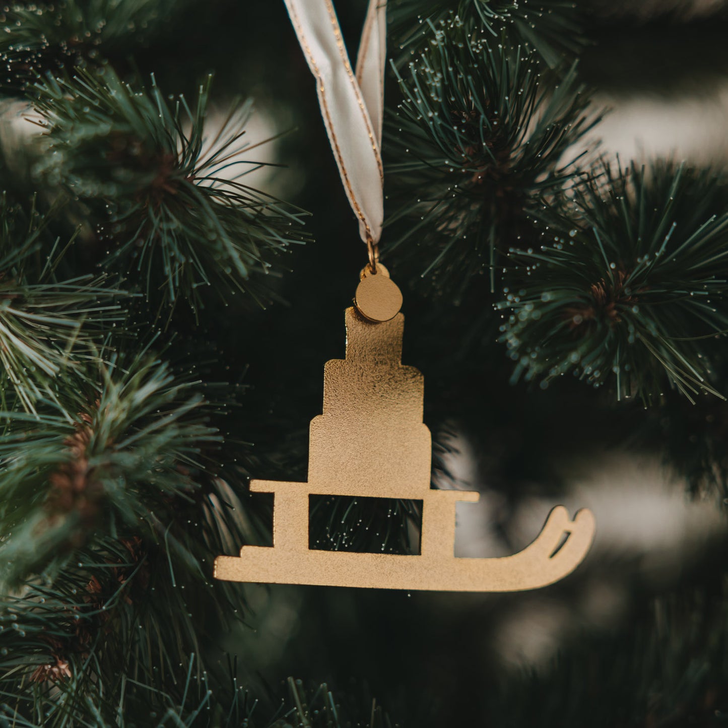 Rückseite goldener Schlitten Anhänger am Weihnachtsbaum, minimalistisches Design