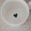 Innenansicht einer weißen Tasse mit kleinem grünem Herz am Boden