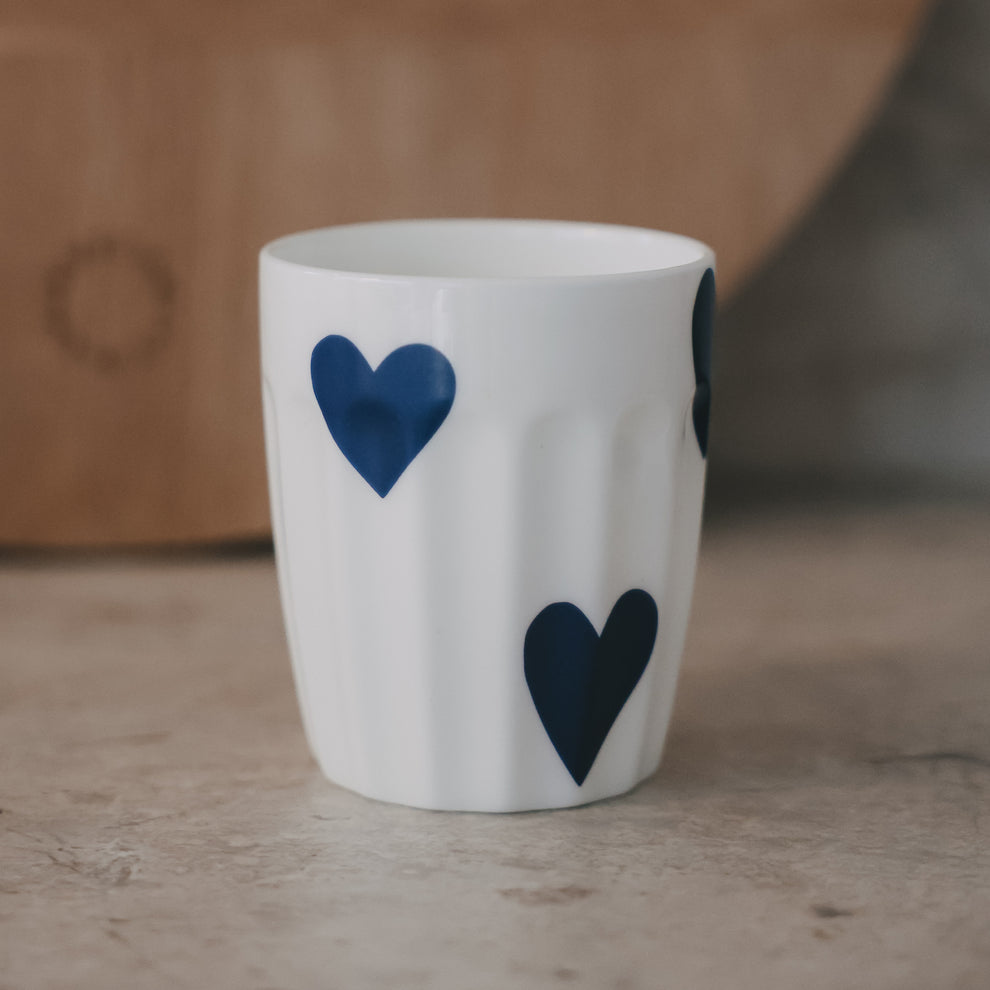 Weißer Keramikbecher mit großem blauem Herzmotiv, minimalistisches Design