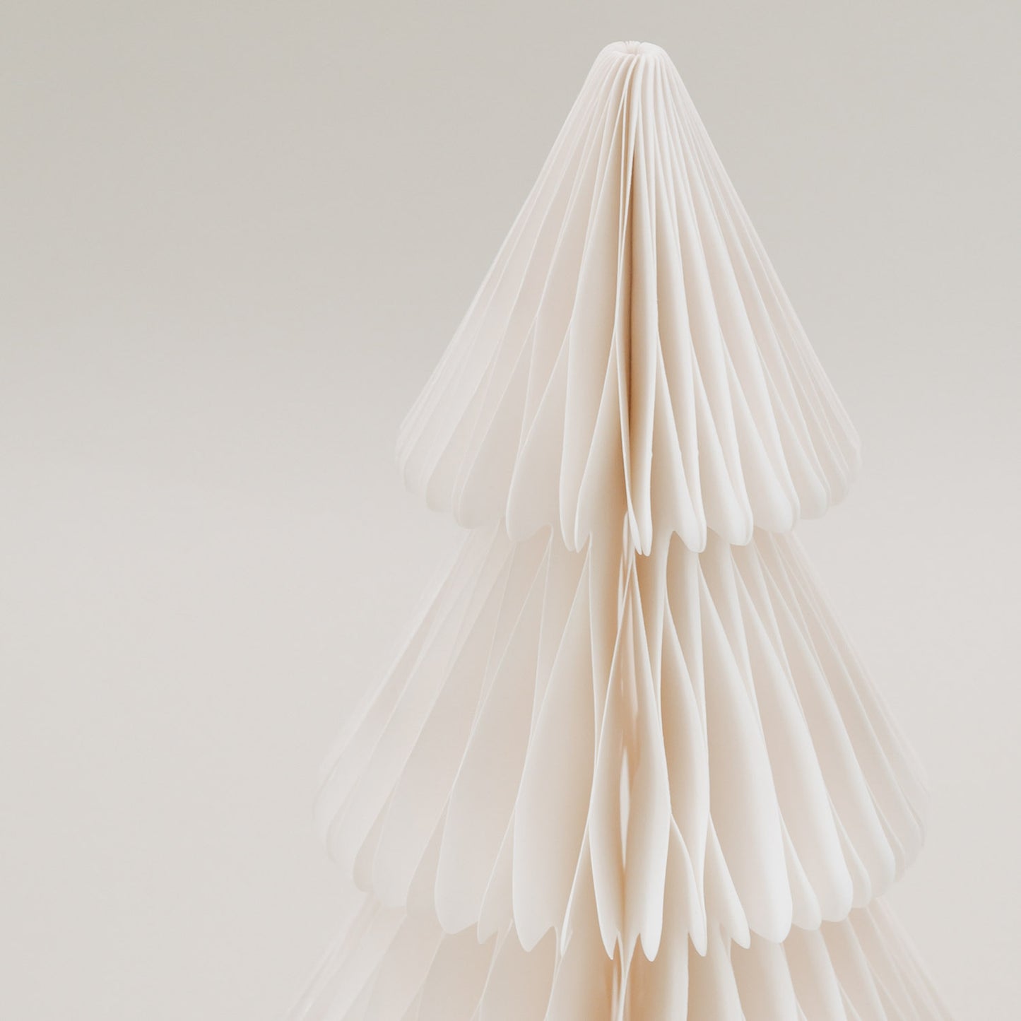 Detailaufnahme der oberen Spitze der naturweißen Papiertanne mit feiner Wabenstruktur aus Papier