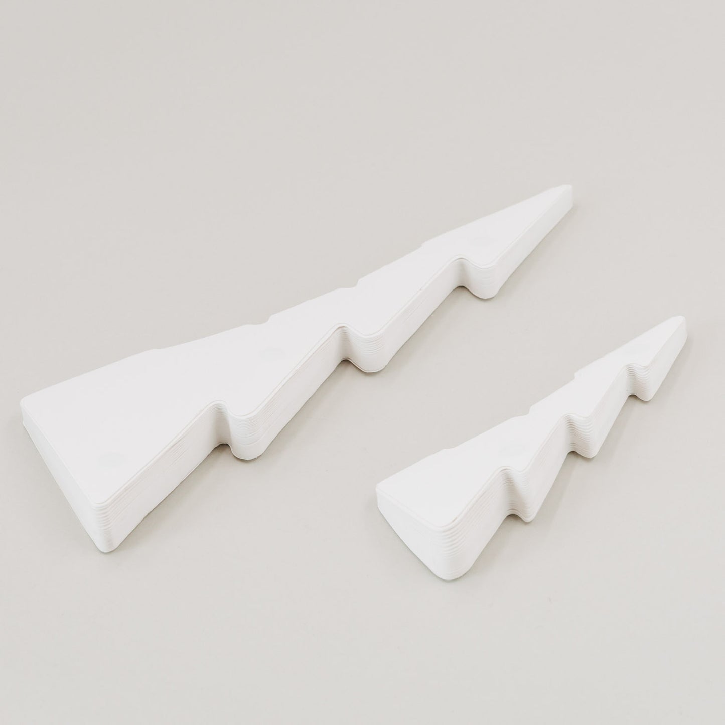 Flach gefaltete naturweiße Papiertannen  mit Magnetverschluss