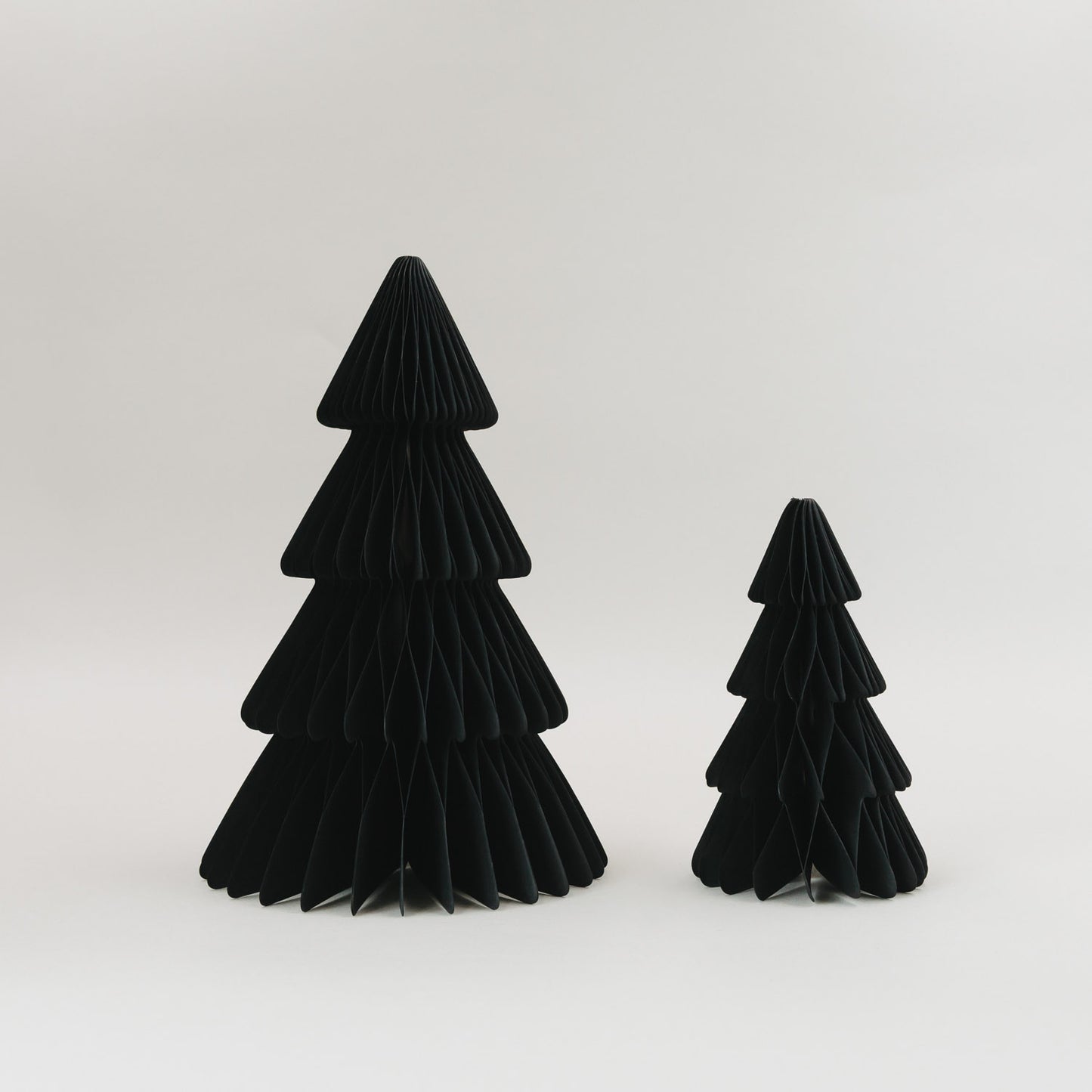Zwei schwarze Papiertannen in Wabenoptik vor hellem Hintergrund – minimalistisches 2er Set zur Weihnachtsdeko
