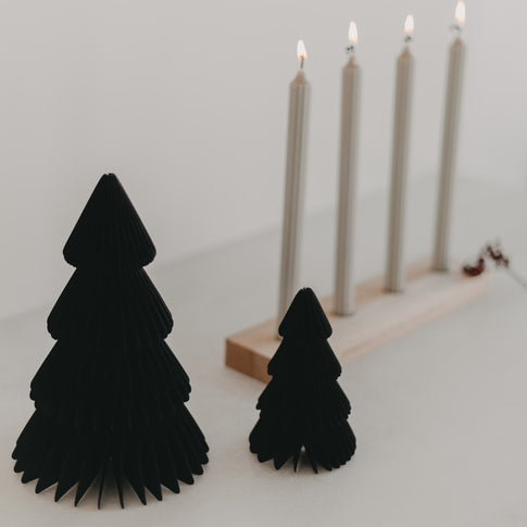 Papiertannen Schwarz als festliche Deko vor Kerzenhalter – stilvoll im modernen Weihnachtsambiente