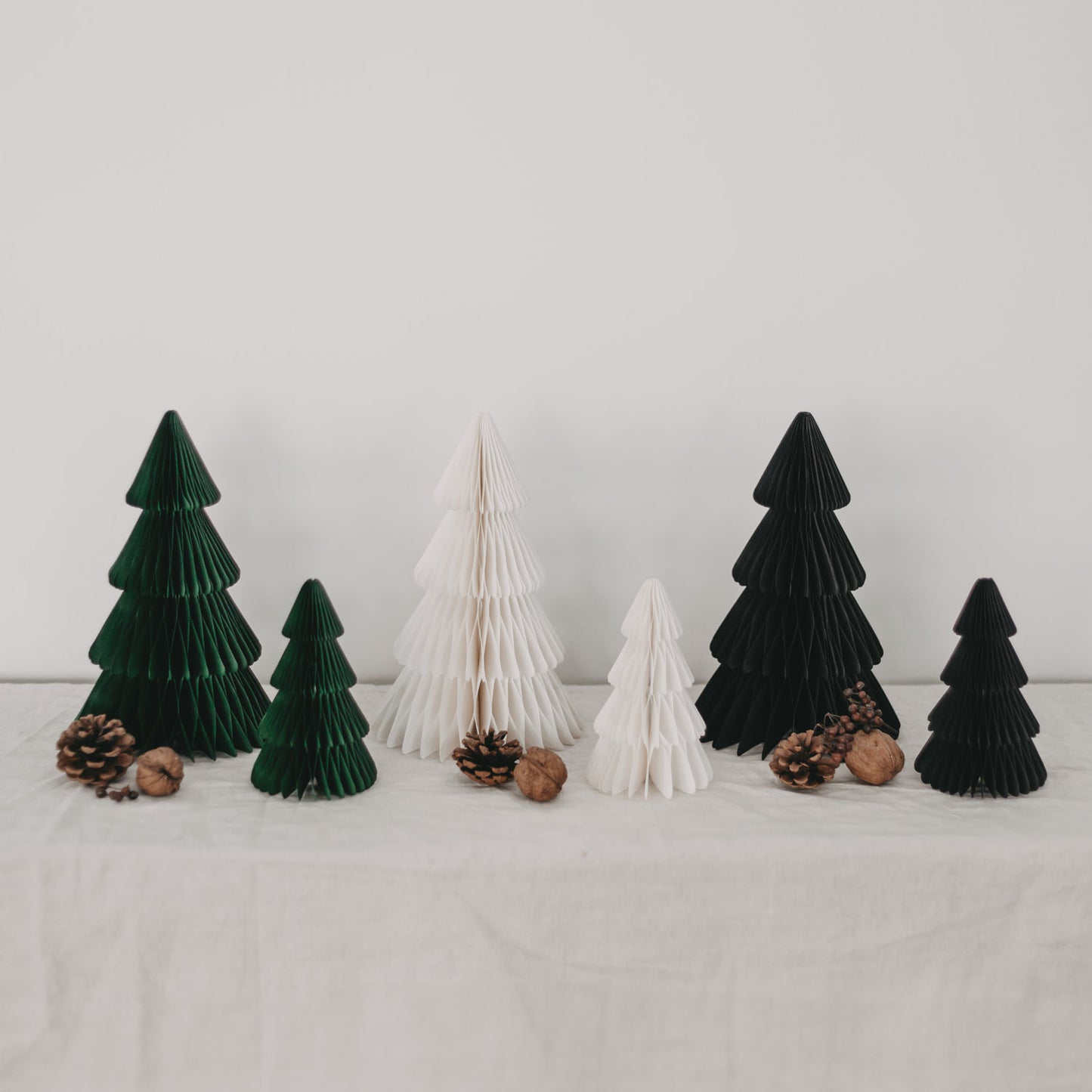Schwarze, naturweiße und grüne Papiertannen im Gruppenbild – ideal kombinierbare Weihnachtsdeko