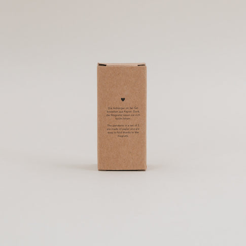 Rückseite der Verpackung mit kurzer Info zu Material, Magnetverschluss und Wiederverwendbarkeit der Anhänger.