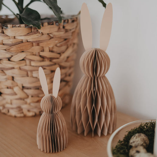 Papierhasen im Set aus Naturpapier in 15 und 25 cm auf Holzoberfläche neben Pflanzenkorb dekoriert.