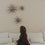 Graue Papiersterne mit warmer Lichterkette als stilvolle Weihnachtsdeko an heller Wand